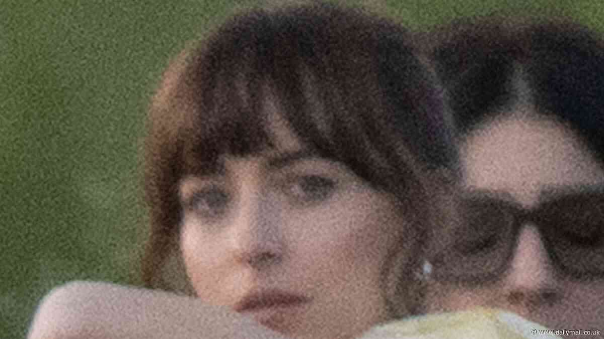 Dakota Johnson revealed a glimpse of her bra and toned tummy as she cuddles up to co-star Chris Evans while filming romantic-comedy Materialists