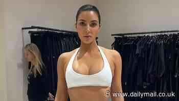 Kim Kardashian shows off her sculpted abs as she rocks a sports bra and crop tops during one of her eye-popping wardrobe fittings