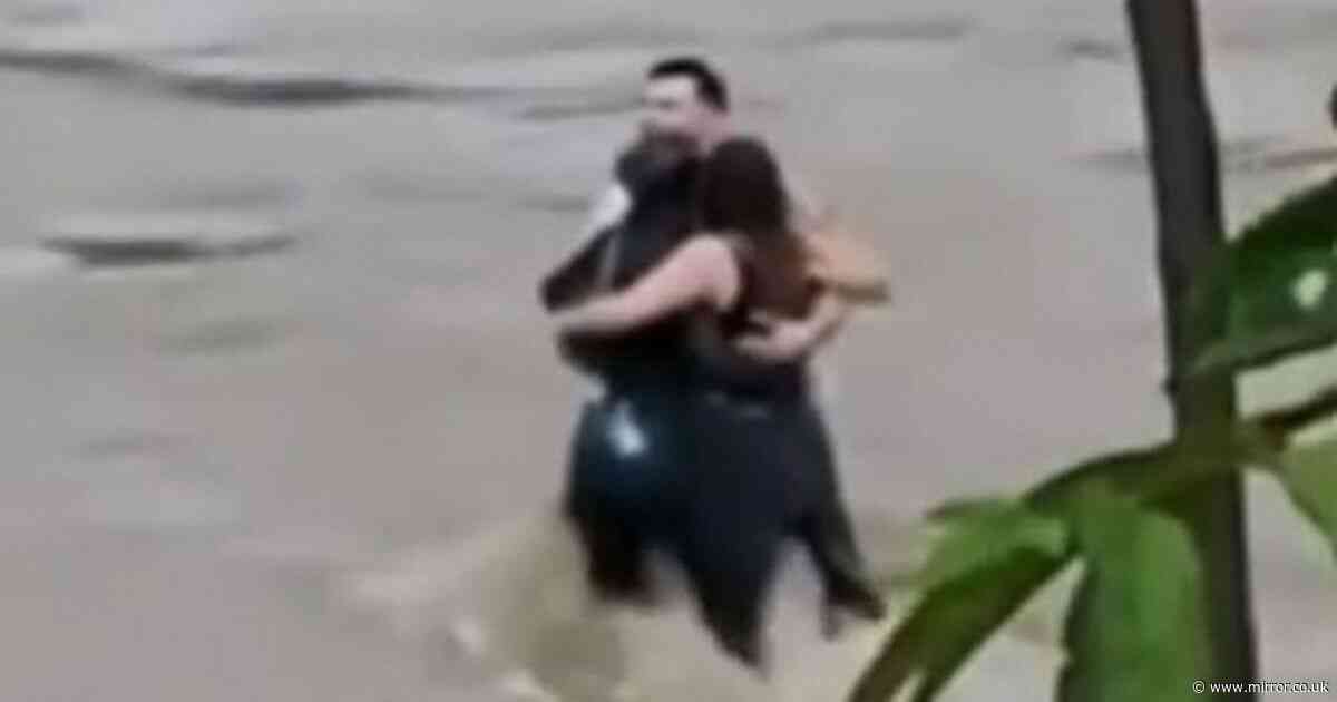 Haunting footage shows three friends hug before being swept away by deadly flood
