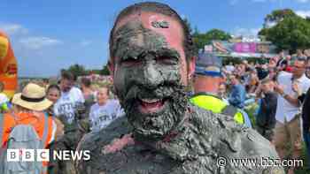 Hundreds plunge into river mud for 50th annual race
