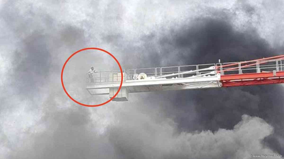 Moment man stands on edge of crane surrounded by thick black smoke in Canning Town fire