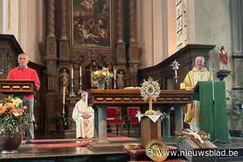 Priester zegent kruisbeeld van vernieuwde parochiezaal in