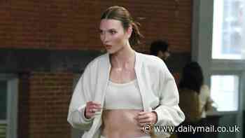Karlie Kloss bares her washboard abs in beige sports bra and leggings as she shoots a commercial in New York City