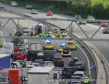 Queues building and police on scene after vehicle overturns on M56