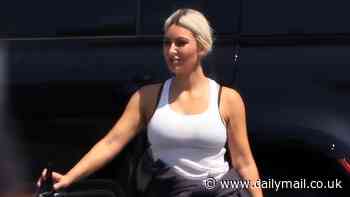 Kim Kardashian is unusually casual in a white tank top with her bra straps showing as her black roots are exposed during Los Angeles outing