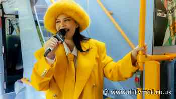 Anne-Marie cuts a quirky figure in a bright yellow suit and faux fur hat as she surprises fans with an impromptu performance - three months after welcoming daughter Seven