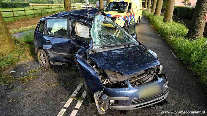 Auto raakt in een slip en botst hard tegen boom, bestuurder gewond