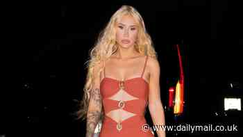 Iggy Azalea reveals a hint of her abs in a daring orange cut-out midi dress as she steps out in New York City