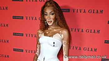Winnie Harlow wears tiny white mini skirt with matching bodice featuring jeweled nipple piercings and belly ring at the Viva Glam Billion Dollar Ball in New York City