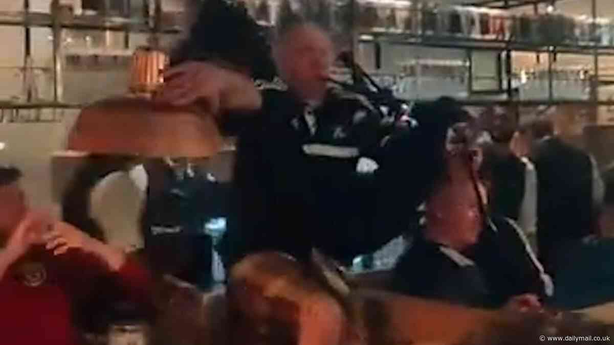 Tartan Army's Munich invasion: Hilarious moment bagpiper falls off table while serenading packed bar as kilted Scotland supporters descend on city to down steins and sing in the streets - after Glasgow airport ran out of Tennent's Lager at 9AM