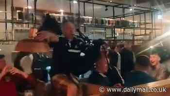 Tartan Army's Munich invasion: Bagpiper falls off table while serenading packed bar as kilted Scotland supporters descend on city to down steins and sing in the streets - after Glasgow airport ran out of Tennet's Lager at 9AM