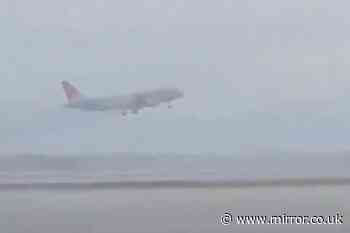 Dramatic moment pilot of packed passenger jet aborts his landing during storm