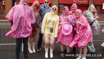 Taylor Swift thanks poncho-wearing Swifties for waiting hours in the rain as she takes to the stage at Anfield for her 100th Eras Tour show wearing pink bejewelled bodysuit