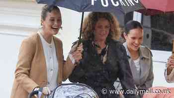 Simone Holtznagel makes a bold statement with X-rated umbrella as she braves the rain for dinner with her sisters Madeline and Anna in Coogee