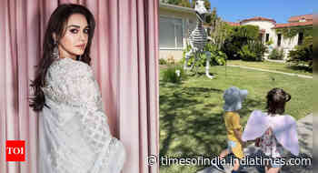 Preity 's twins are amused with a Dinosaur statue