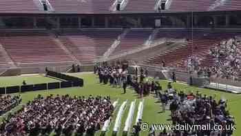 Stanford University graduation chaos as HUNDREDS of students waving Palestinian flags and keffiyehs walk out during President Richard Saller's speech