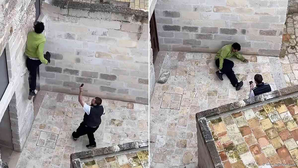 Instant karma for 'British' parkour runner as he damages UNESCO World Heritage Site building during roof-top jump when masonry gives way beneath him - sending him crashing to the ground