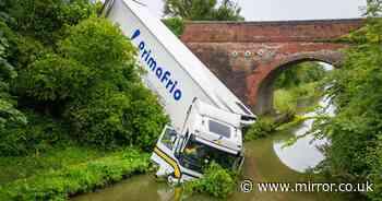 Lorry plunges off bridge and into canal in dramatic early morning crash