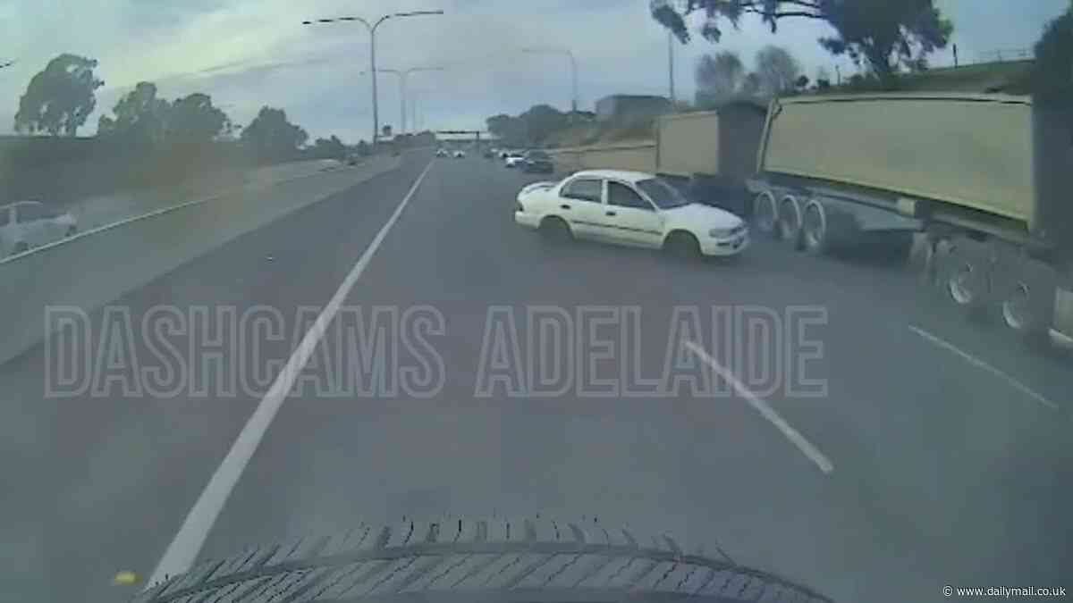 Shocking dashcam footage shows the moment a car swerved across traffic before it nearly disappeared under a huge truck
