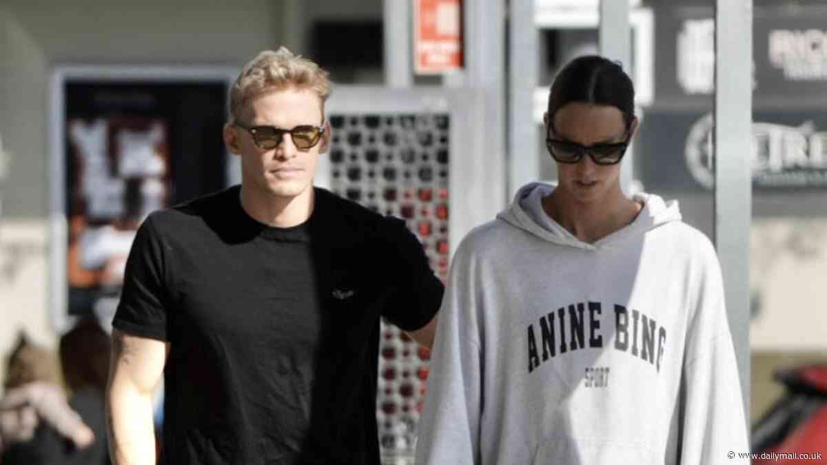 Cody Simpson gives girlfriend Emma McKeon a playful pat on the bottom as they enjoy a romantic stroll on the Gold Coast before she flies to Paris for the Olympics