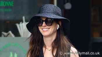 Anne Hathaway looks chic in a waistcoat and straw hat as she runs errands in New York City
