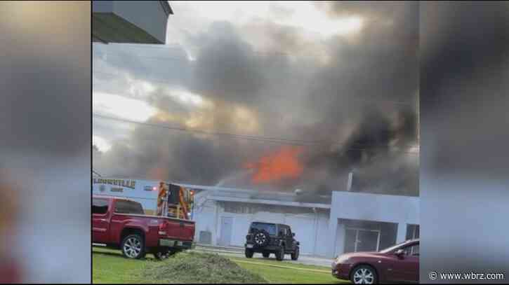 Multiple fire departments work to put out flames at car dealership