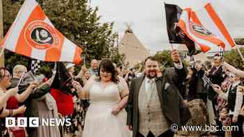 Football fans' wedding photobombed by rival flags
