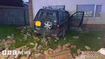 Driver arrested after car crashes into house