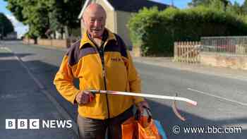 Litter-picking volunteer collects award from village