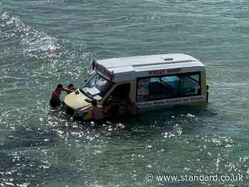Beachgoers haul abandoned ice cream van from sea in Cornwall