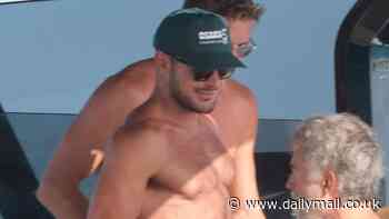 Zac Efron bares his chiseled chest and brawny arms as he goes shirtless on a yacht with friends in Ibiza