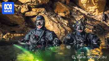 Divers dig a new entrance to an ancient 30-metre-deep cave just metres from a rural road