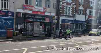 Police cordon in place outside shops on busy Catford road