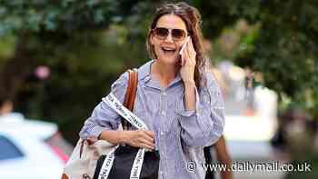 Katie Holmes runs errands in New York City in baggy top and jeans while having animated conversation on phone