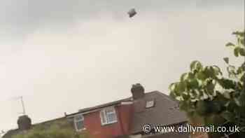 'Has anyone lost a trampoline?' Moment 'mini-tornado' hits storm-ravaged town sending debris flying everywhere... before local makes hilarious discovery