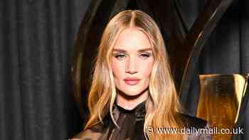 Rosie Huntington-Whiteley stuns in a satin shirt dress complete with suspender stockings at Yves Saint Laurent's Paris Fashion Week show