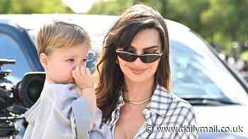 Emily Ratajkowski puts on a busty display in a checked shirt and leather skirt as she brings son Sylvester Apollo Bear, 3, to Loewe's show during Paris Fashion Week