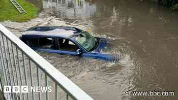 Driver rescued and schools shut as rain falls