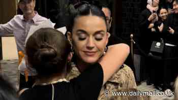 Katy Perry sweetly hugs a young fan as she signs autographs outside her Melbourne hotel after her AFL Grand Final headlining gig