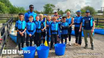 Young footballers in canoes clear litter from canal