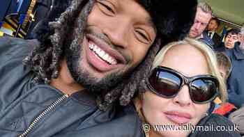 Madonna, 66, cuddles toy boy lover Akeem Morris, 28, at football game in London - while confirming her 15th studio album is on the way