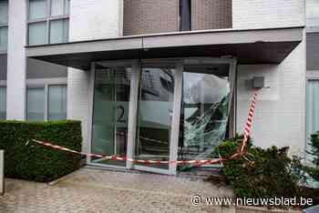 Bestuurster ramt glazen inkomhal van appartementsgebouw