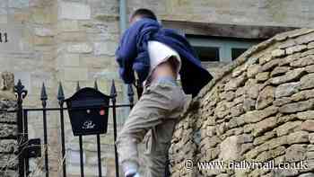 Selfie-hunting tourists jump over garden fences and climb on walls to get the perfect picture in Cotswold village