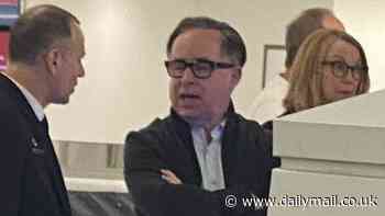 Alan Joyce is forced to wait for his baggage at an airport carousel like everyone else - after losing $9million bonus for trashing Qantas' reputation