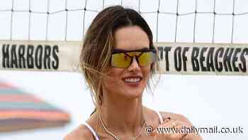 Alessandra Ambrosio flaunts her sculpted physique in a green one-piece suit as she shares her athletic prowess during beach volleyball match