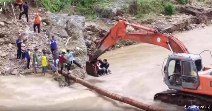 Woman about to give birth given huge lift by digger to help her cross flooded river