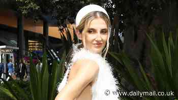 Kate Waterhouse puts on a quirky display in an elegant white feathered gown as she joins Grace Hayden leading the stars at Royal Randwick's Everest race day in Sydney