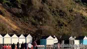 Terrifying moment man comes within inches of being wiped out by flying beach hut as landslide hits popular beach