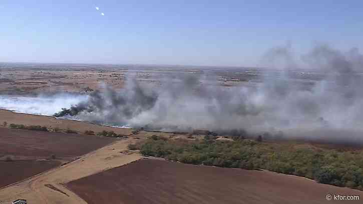 Firefighters battle grass fire threatening homes, barns in SW Logan County