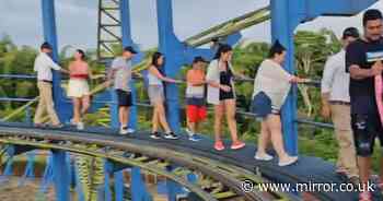 Moment stranded thrill-seekers forced to flee broken rollercoaster on precarious track